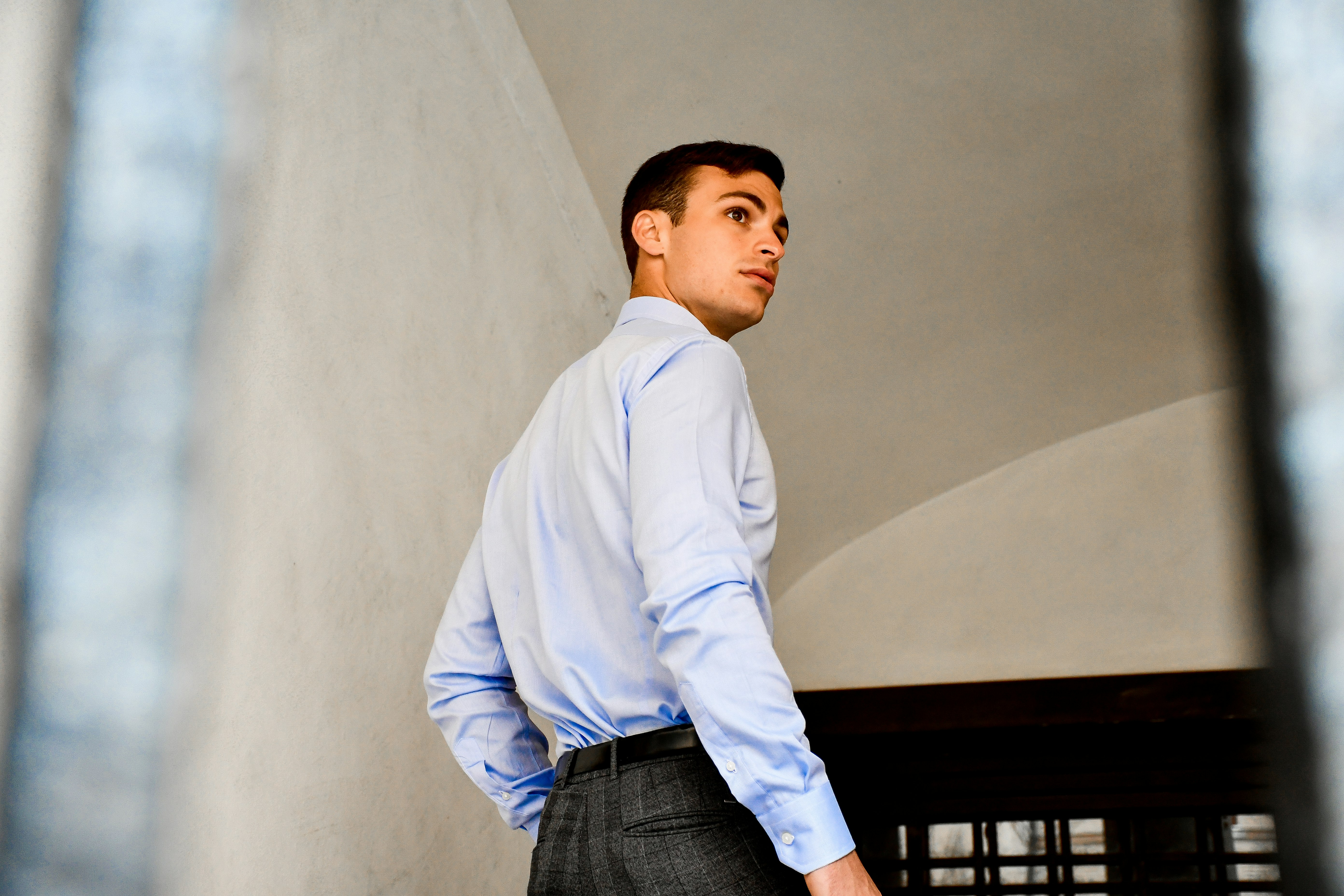 man in white dress shirt and blue denim jeans standing